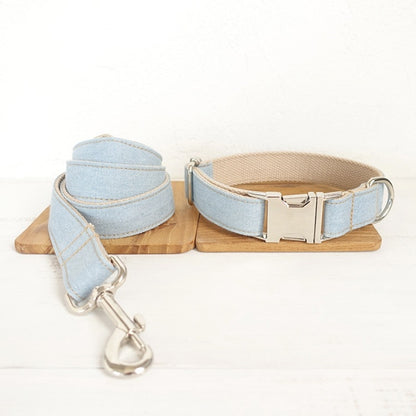 Dog collar and leash set with light blue fabric on a wooden stand against a white background